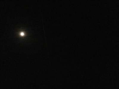 満月と飛行機雲の写真